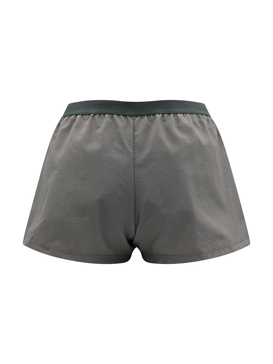 Grey athletic shorts with black waistband on a white background