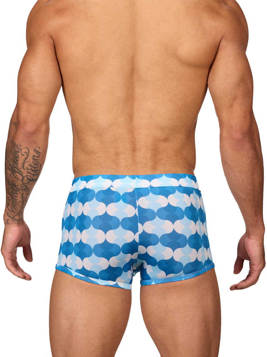 Rear view of a male model wearing Body Aware men's boxer briefs in a blue and white wave patterned print, featuring a contoured pouch.