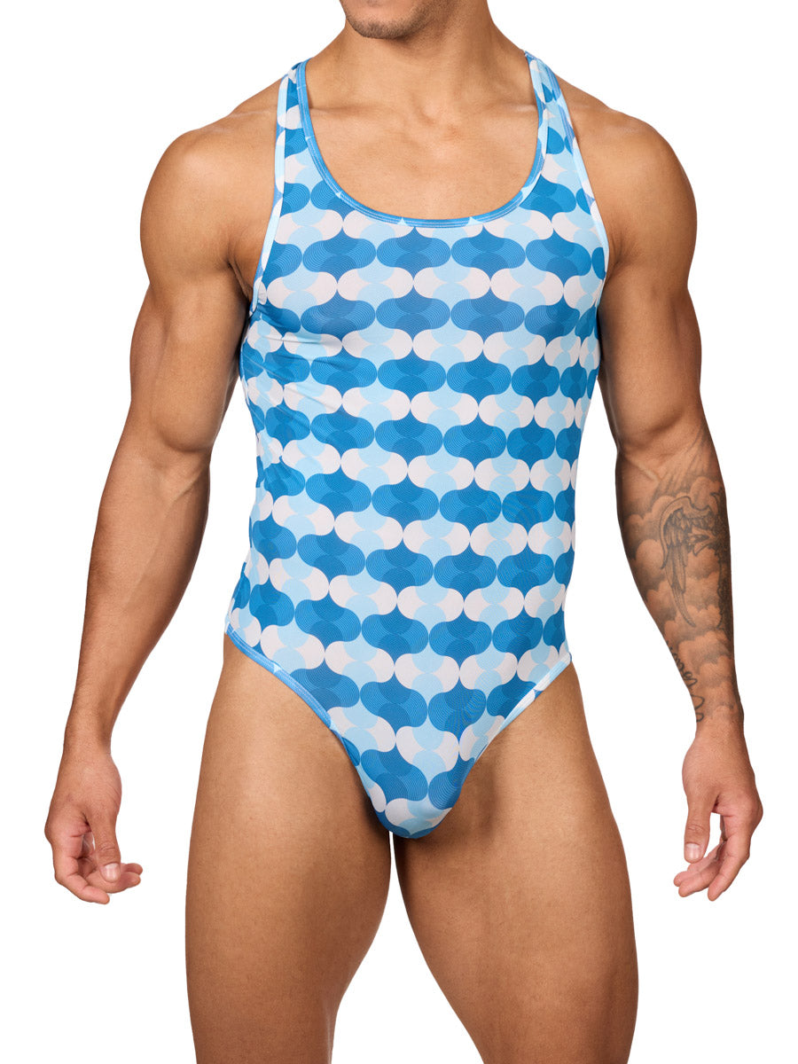 Front view of a male model wearing a Body Aware men's thong bodysuit in a blue and white wave patterned print, featuring racerback shoulder straps.