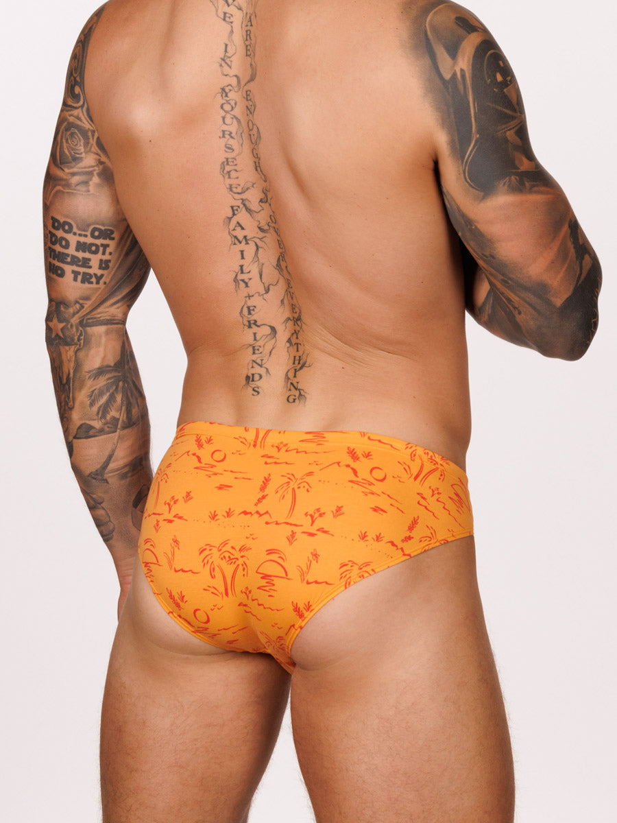 Back view of male model wearing an orange Body Aware brief with red tropical designs