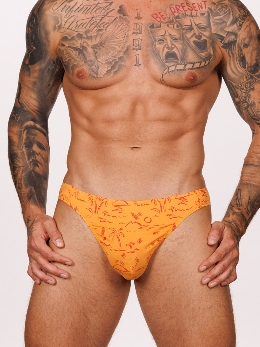 Front view of a male model wearing an orange Body Aware thong