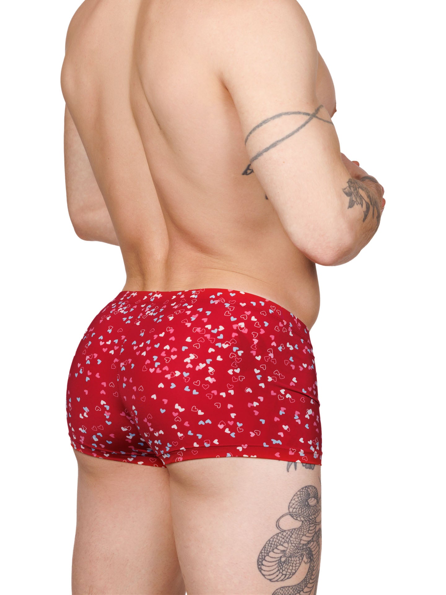 Back view of a male model wearing red Body Aware boxer shorts with a multicolor heart pattern