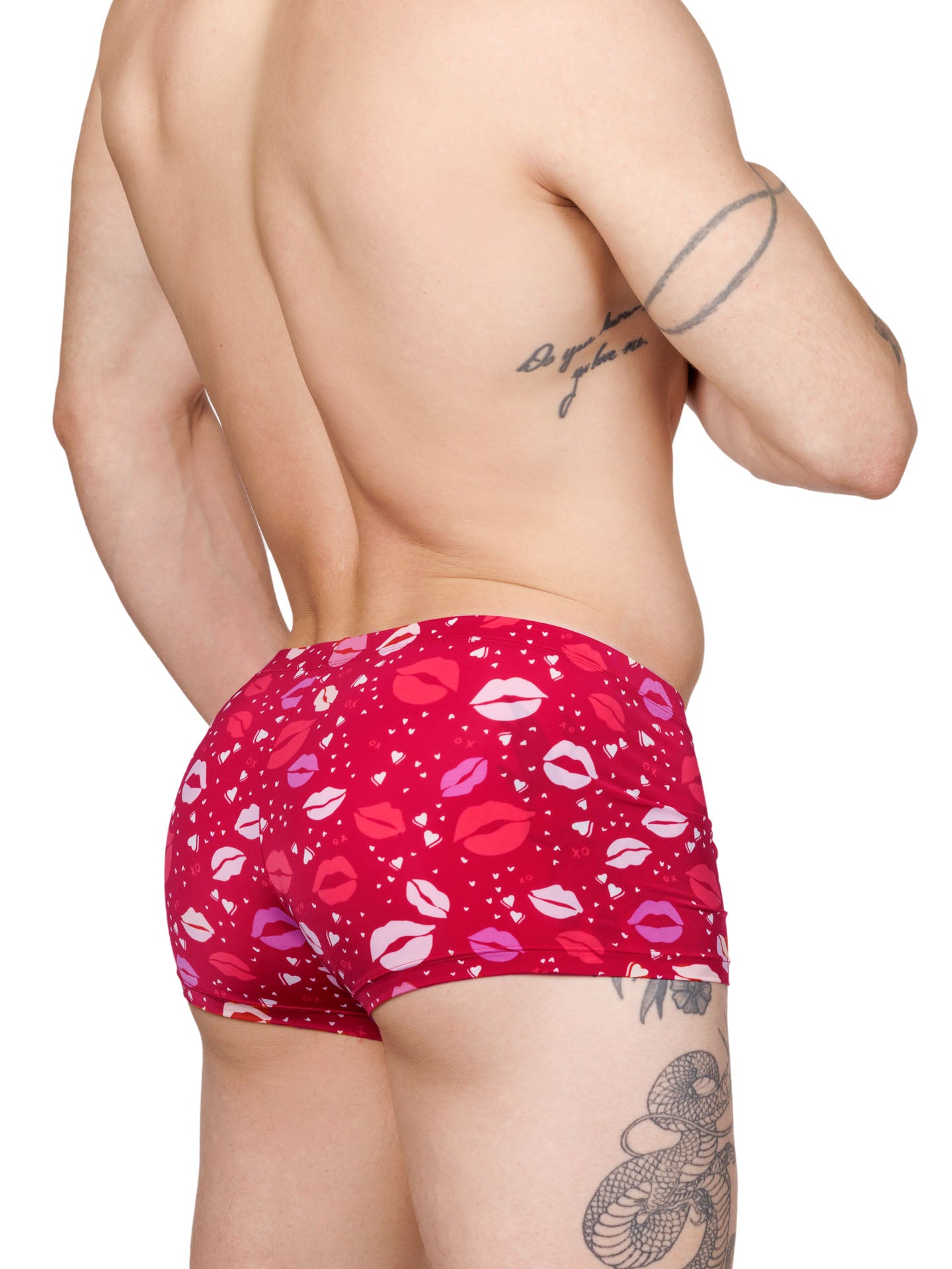 Side view of a male model wearing red Body Aware boxer shorts with a lipstick kiss pattern