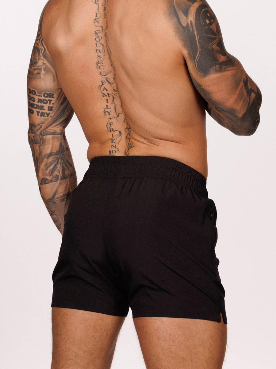 Back view of a male model wearing black Body Aware athletic shorts