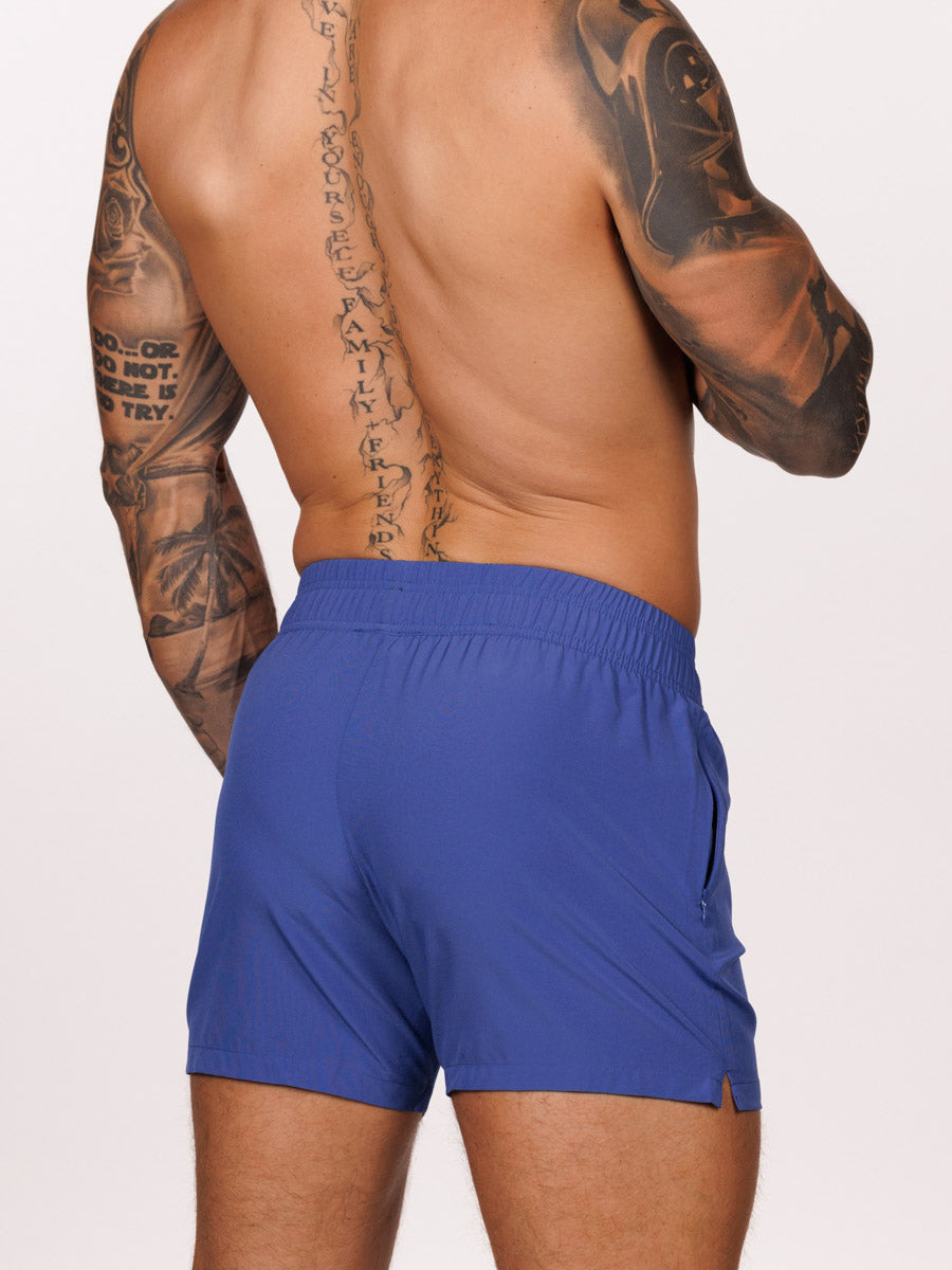 Back view of a male model wearing blue Body Aware athletic shorts