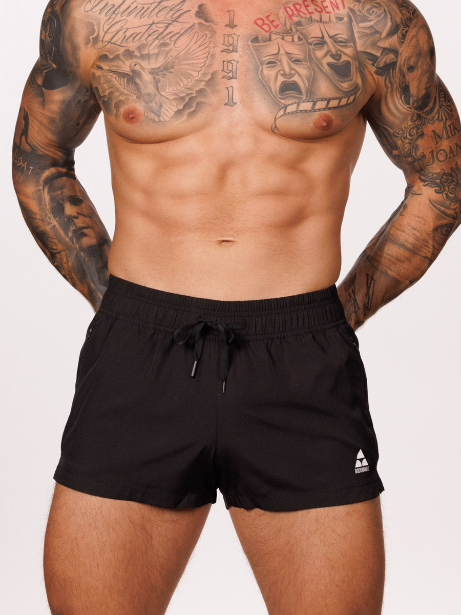 Front view of a male model wearing black Body Aware gym shorts with drawstring