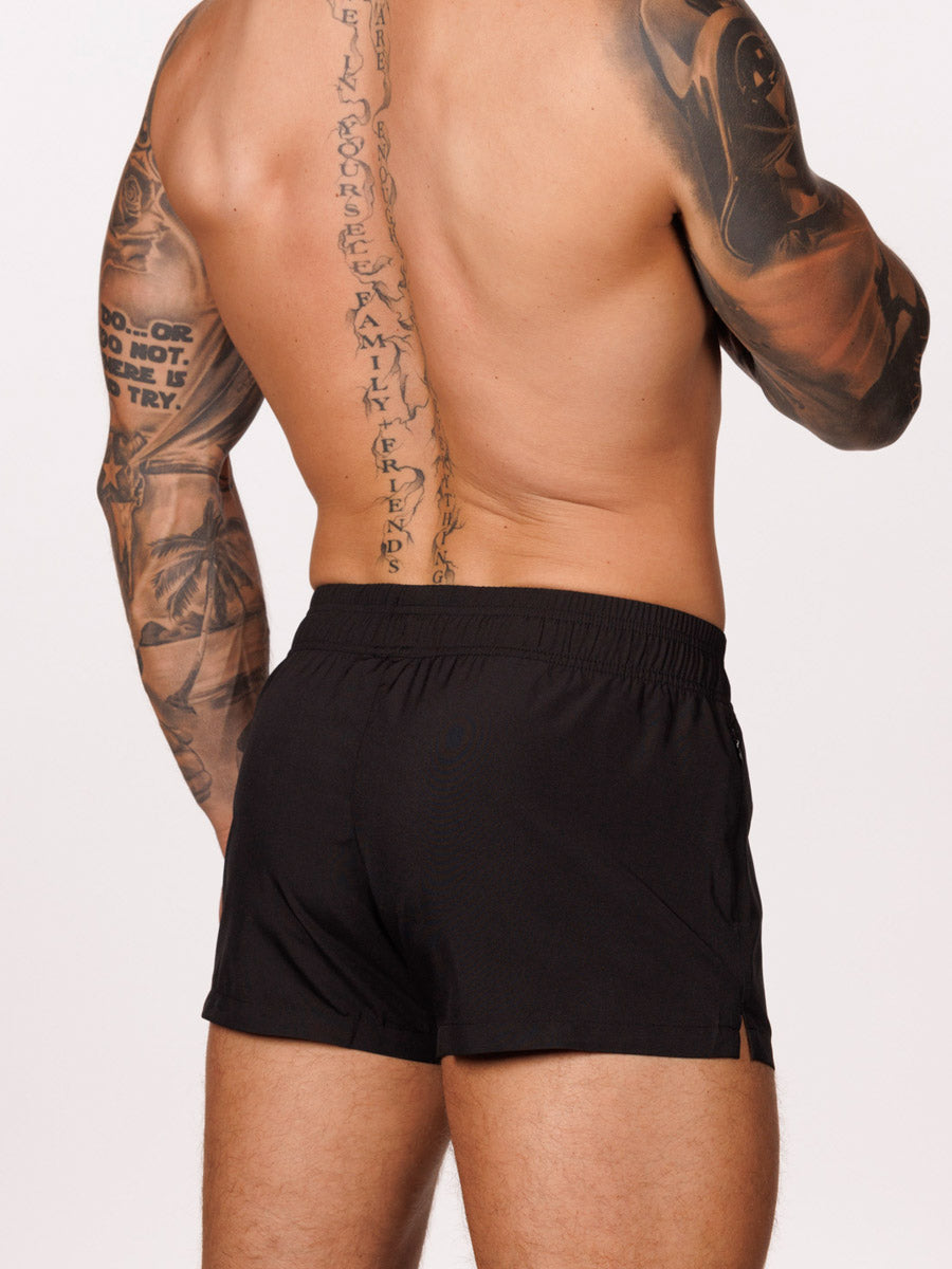 Back view of a male model wearing black Body Aware gym shorts