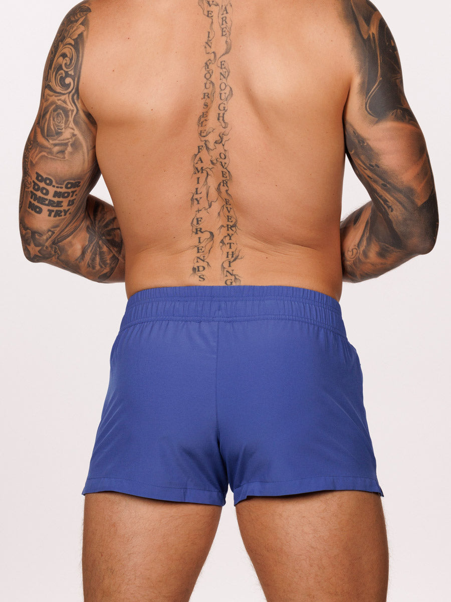 Back view of a male model wearing blue Body Aware square leg gym shorts 