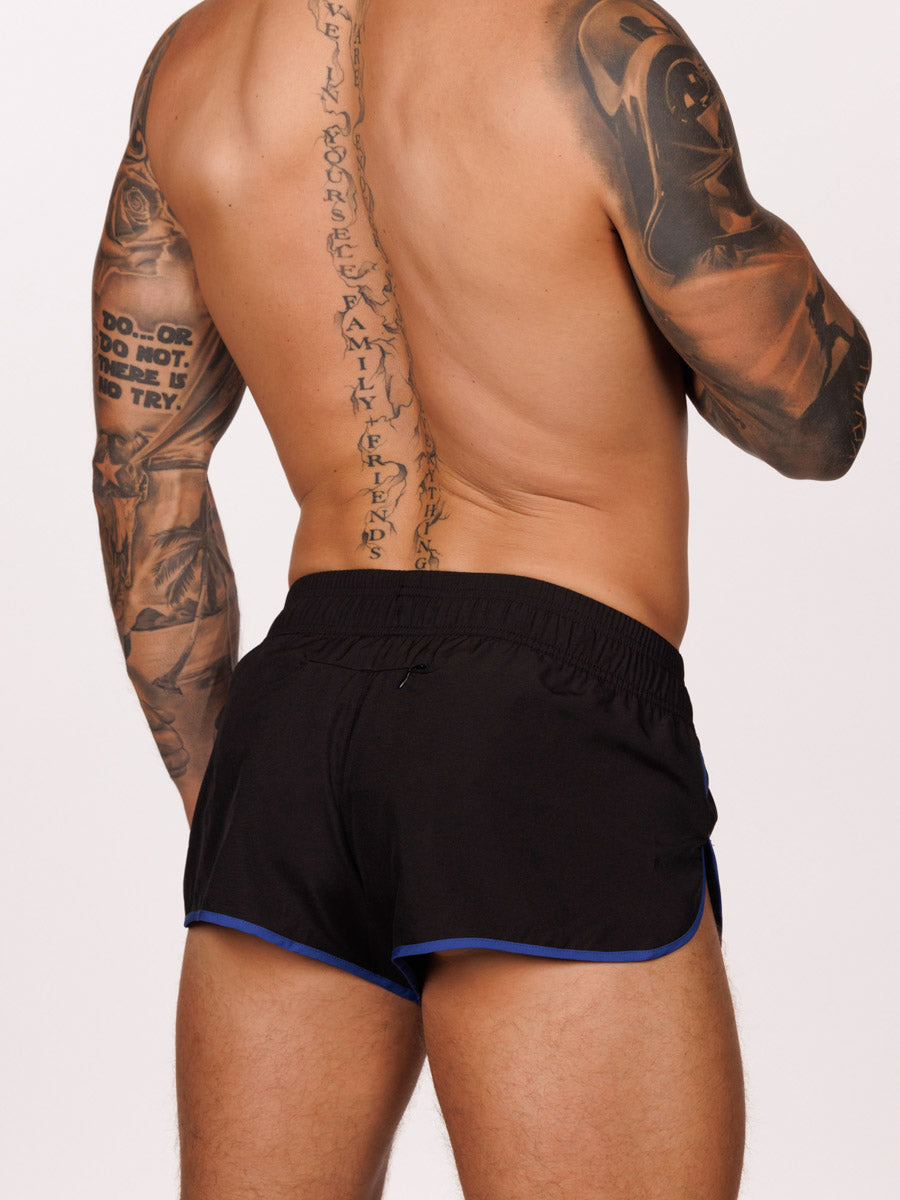 Back view of a male model wearing black Body Aware running shorts