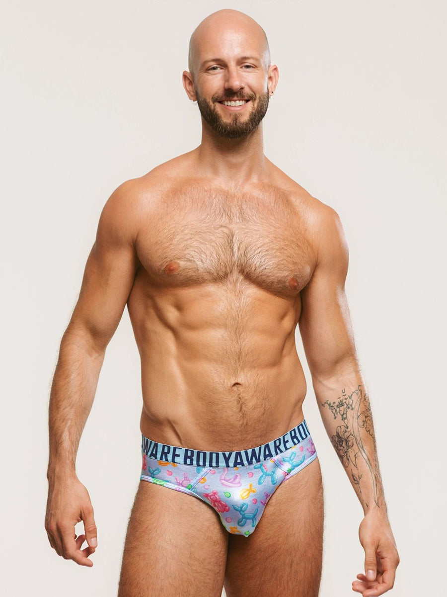 Front view of a man wearing light blue satin briefs with a Body Aware branded waistband.
