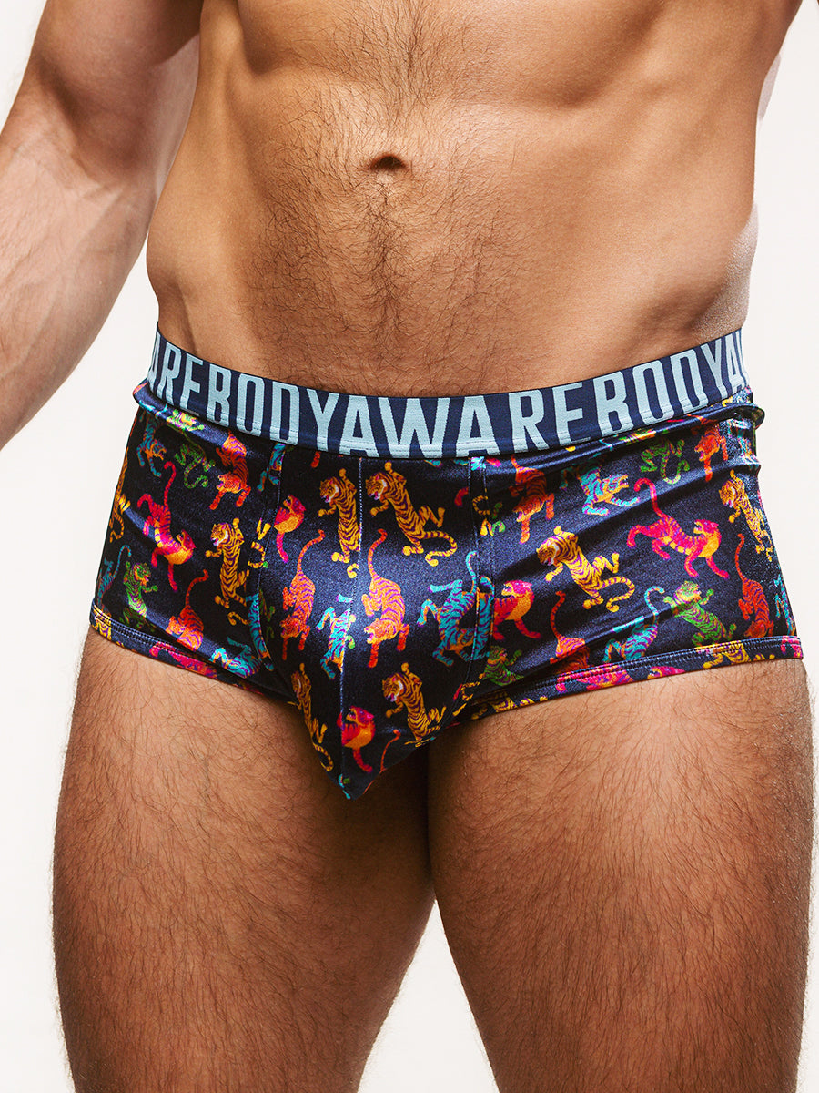 Closeup view of a man wearing navy blue satin boxers with a Body Aware branded waistband