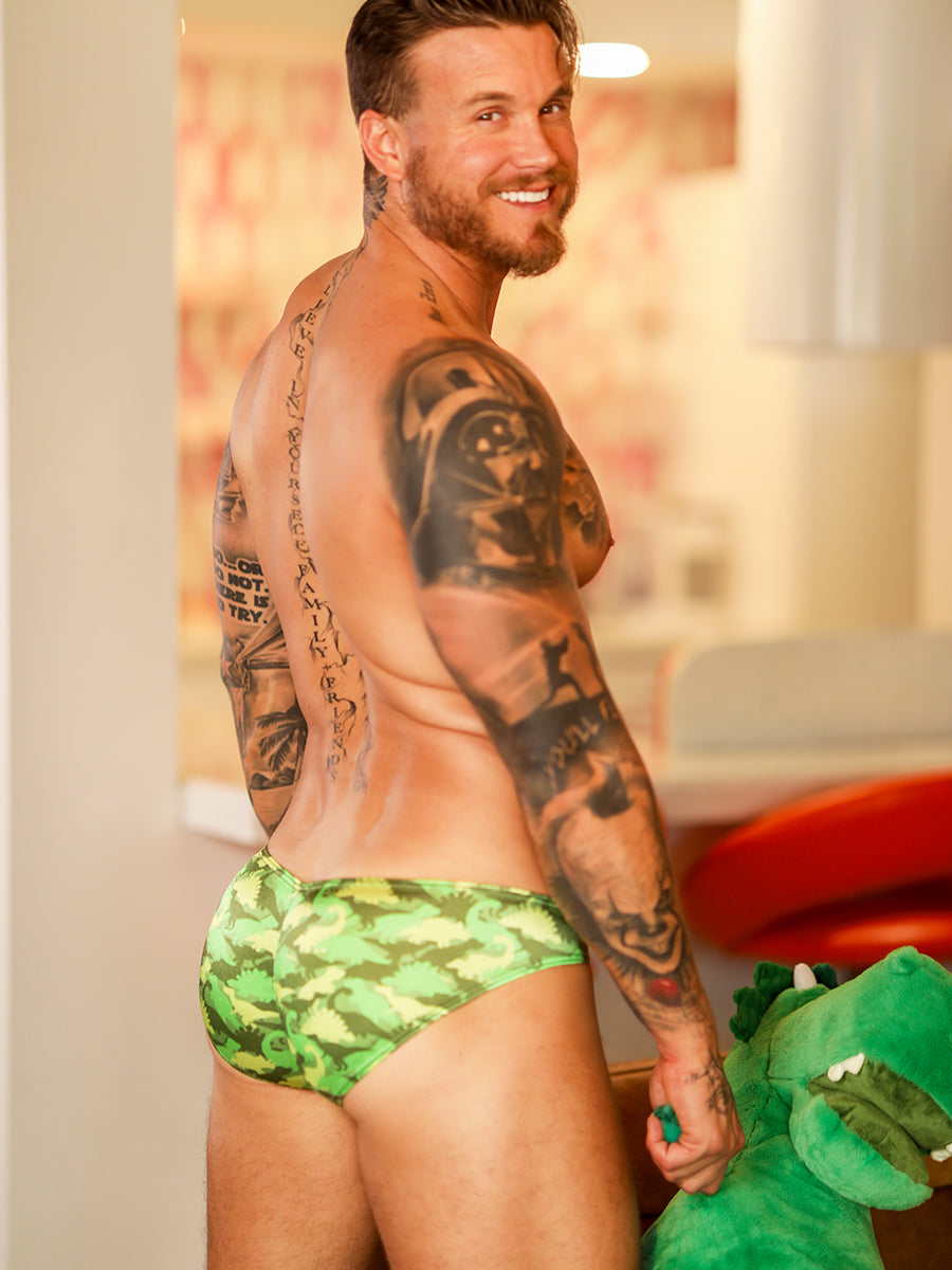 Back view of a male model wearing a green satin Body Aware brief with camo pattern