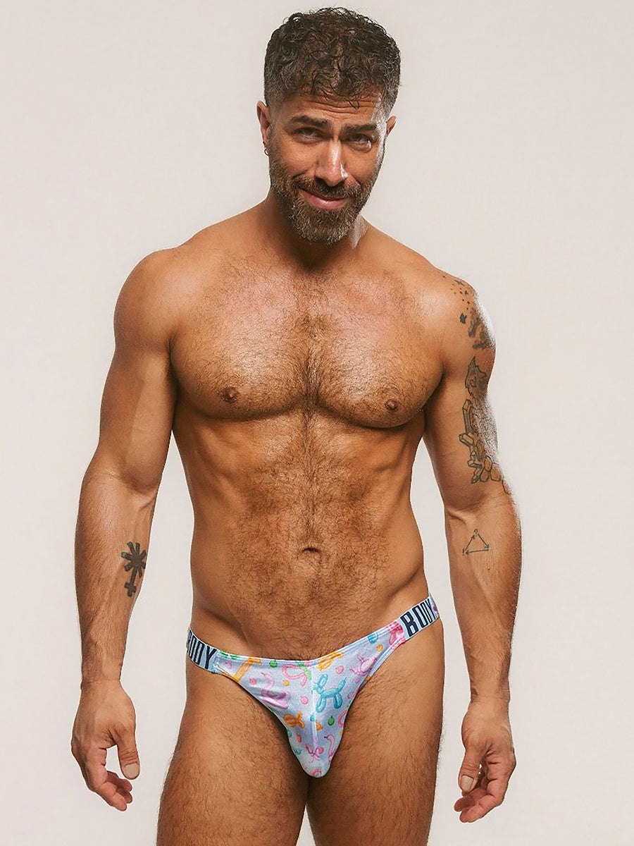 Front view of a man wearing light blue satin briefs against a plain background.