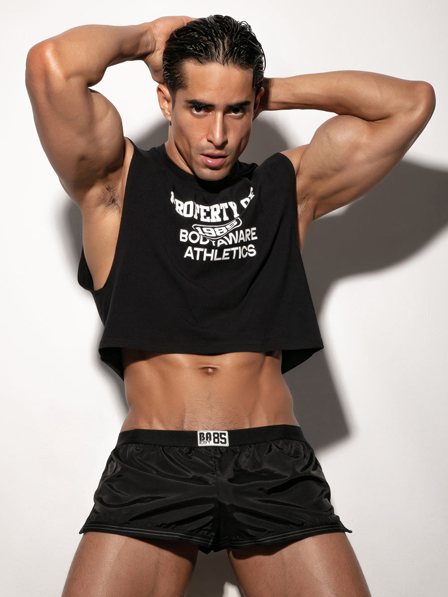 Man wearing a black sleeveless shirt and shorts against a white background