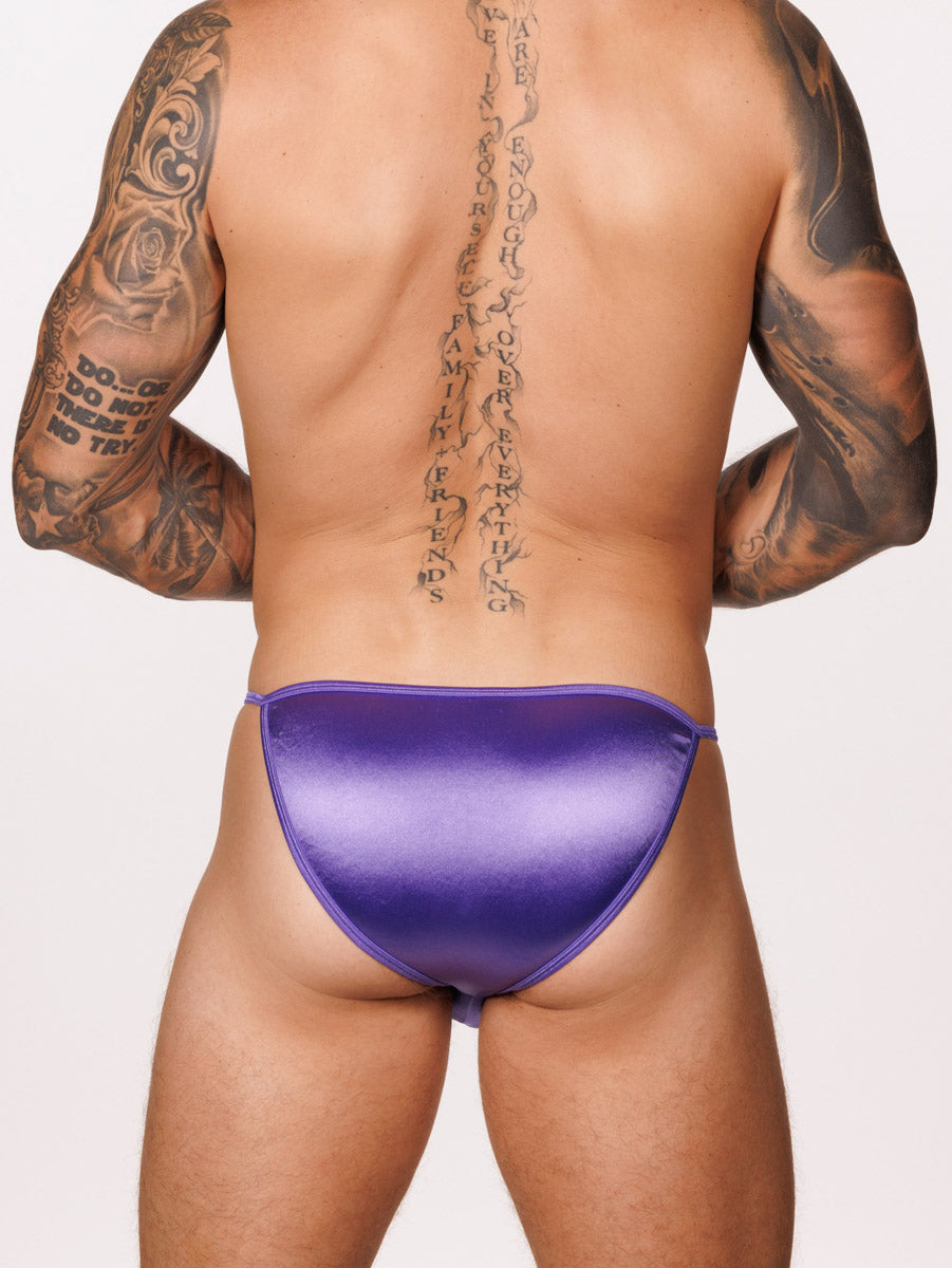 Back view of a male model wearing a purple satin Body Aware bikini brief