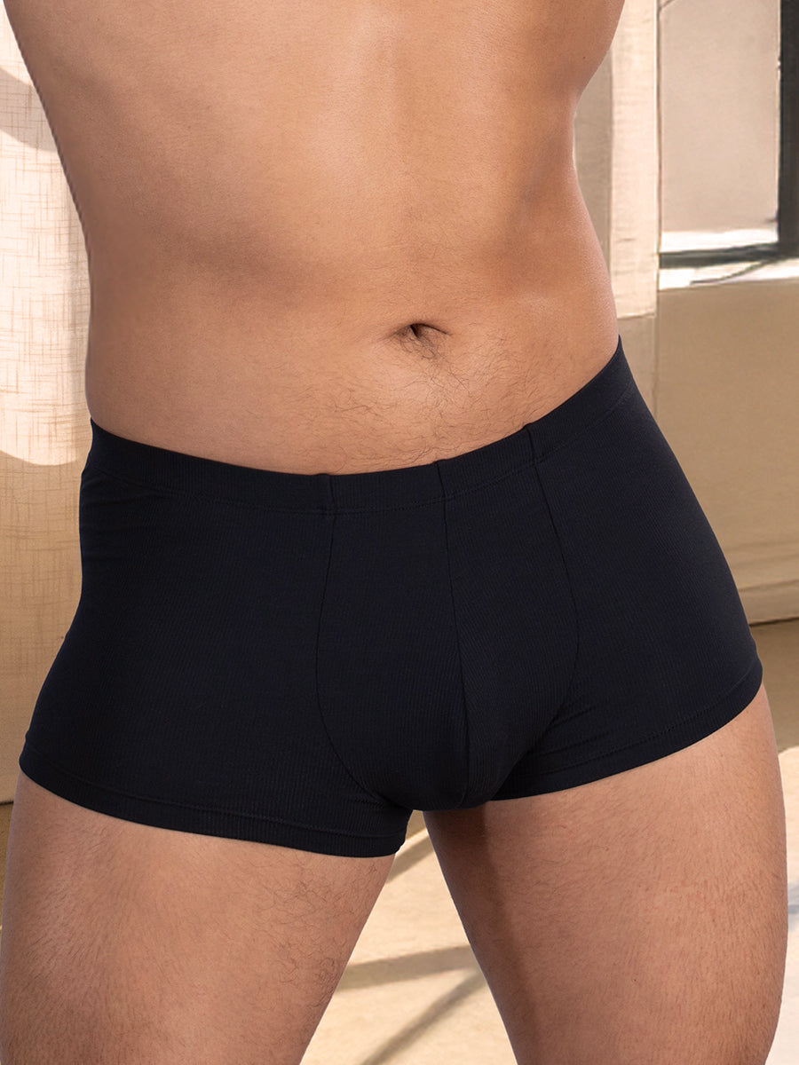 Closeup front view of a man wearing black boxer briefs with a seamed pouch.
