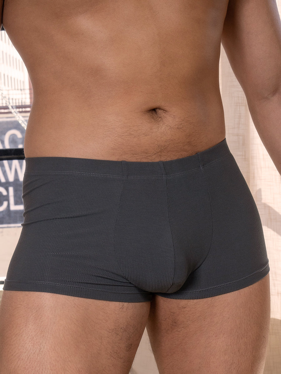 Closeup view of a man wearing grey Body Aware boxers with a seamed pouch.