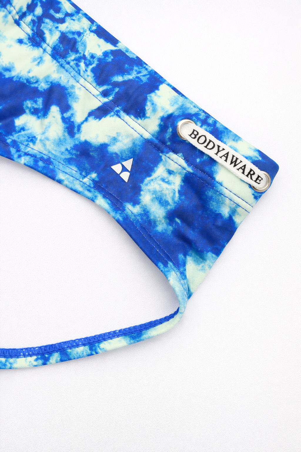 Blue and white tie-dye swim brief with 'BODYAWARE' branding on a white background