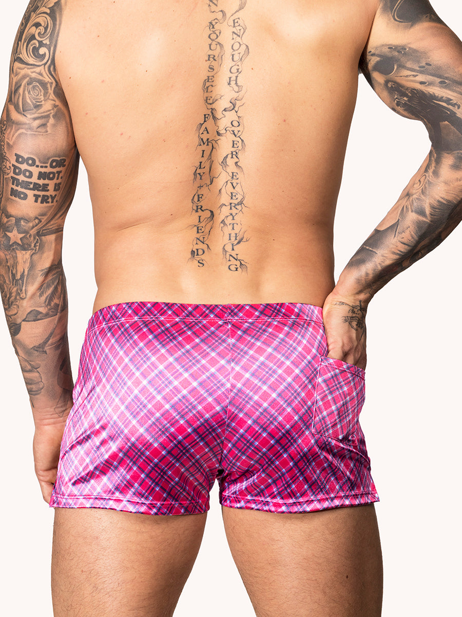 Back view of a male model wearing pink plaid Body Aware shorts 