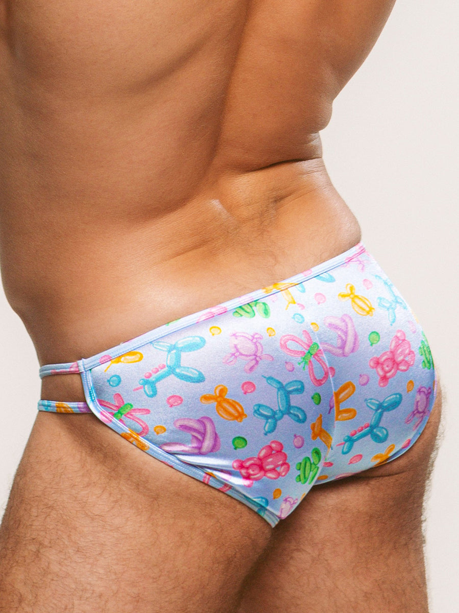 Closeup side view of a man wearing a light blue satin brief with a balloon animal pattern