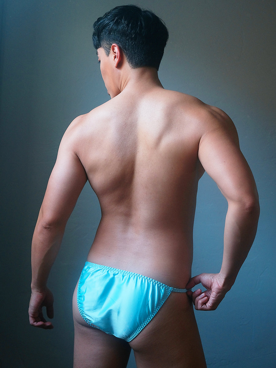 Back view of a male model wearing a Body Aware sky blue men's bikini brief