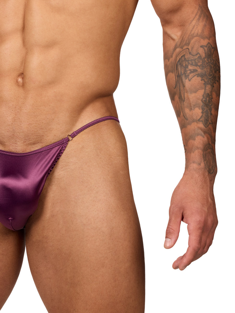 Closeup view of a male model wearing a Body Aware purple men's bikini brief, showing waistband detail. 